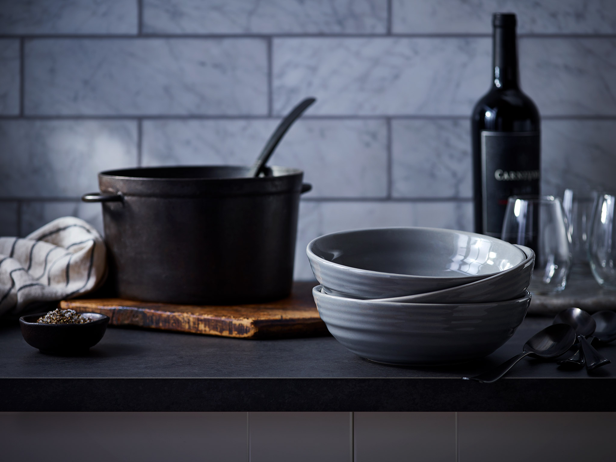 Kitchen scene with soup pot, bowls, and wine