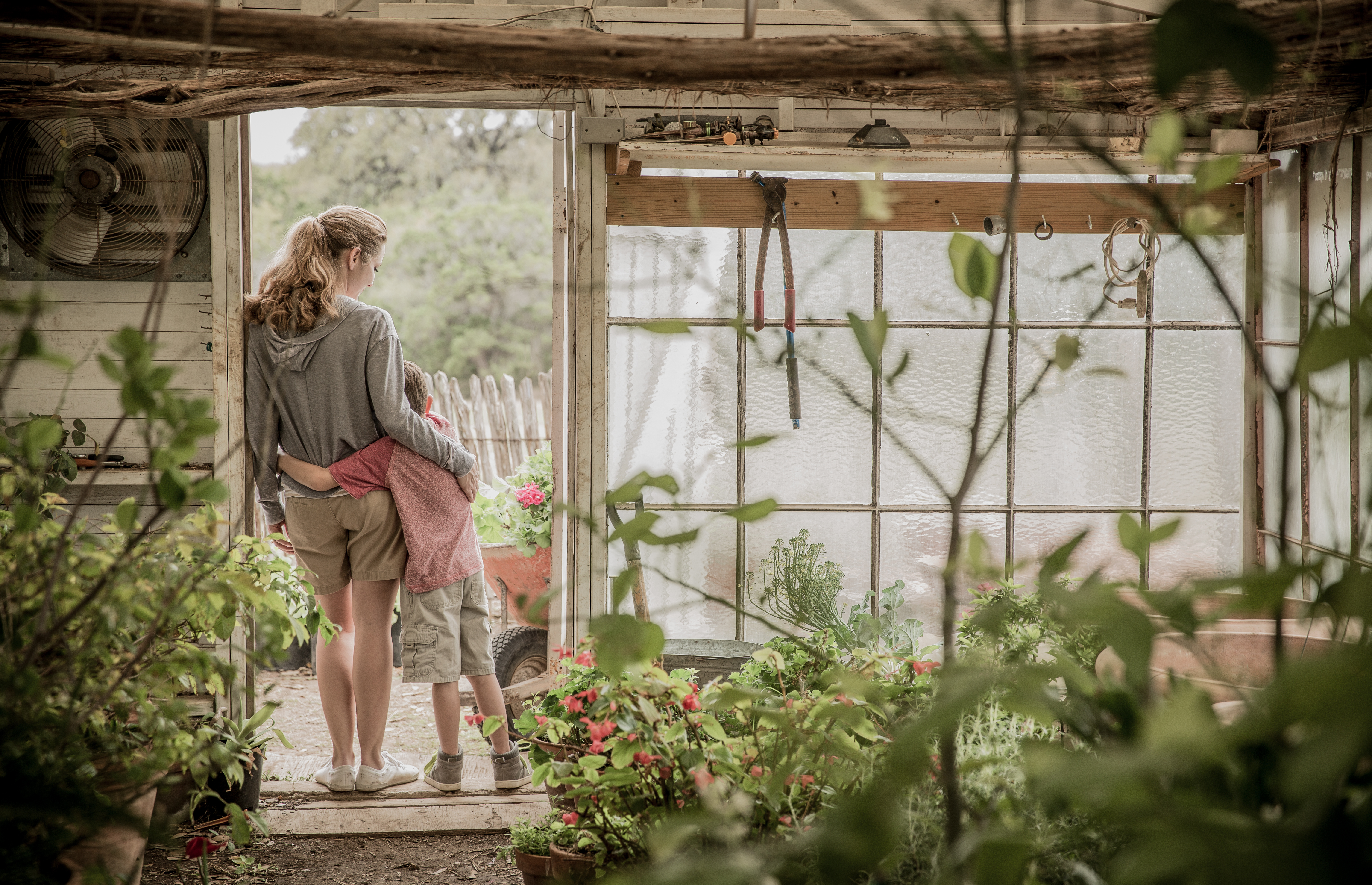 Mom and son spending time together in the garden greenhouse.