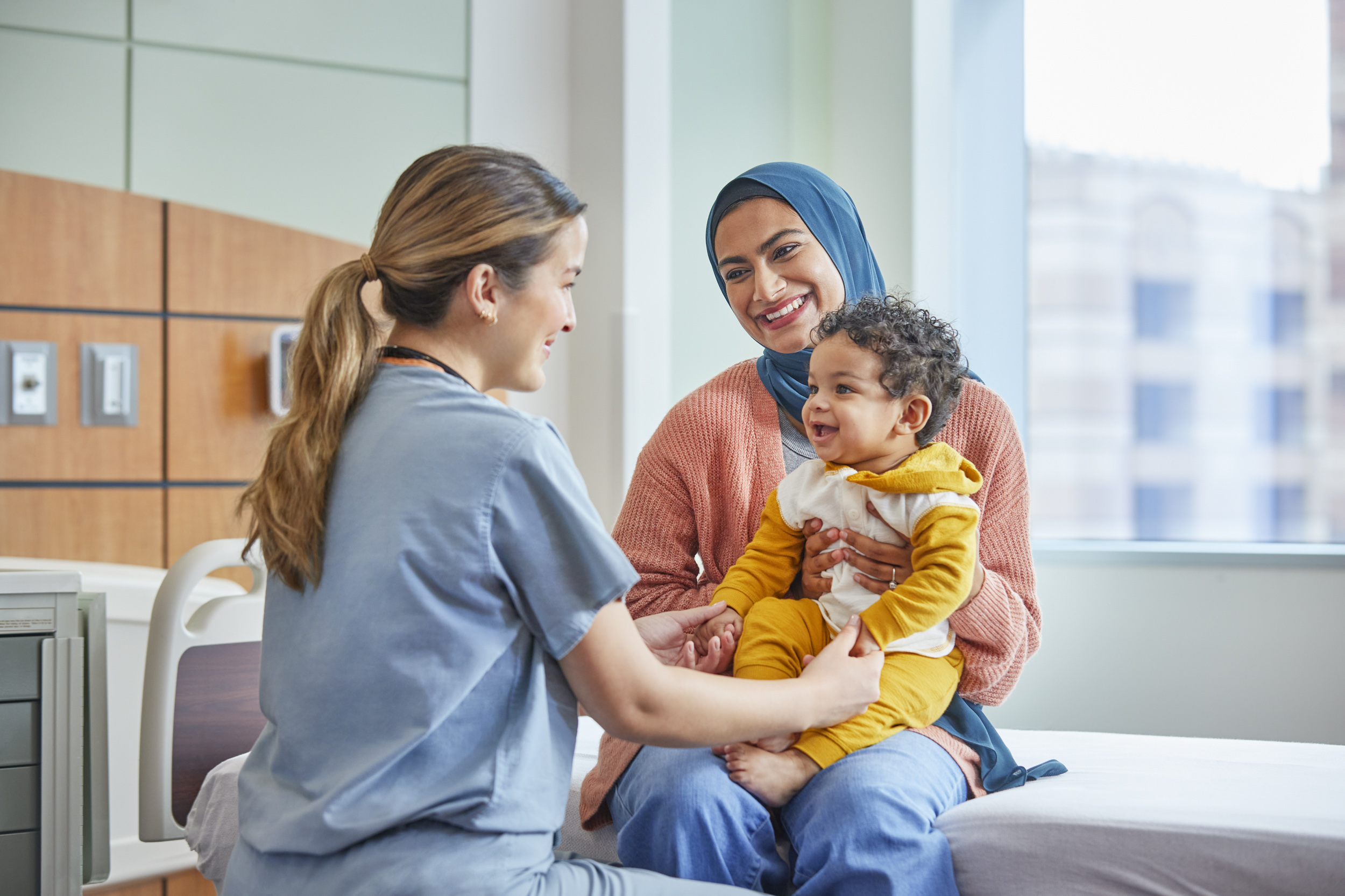 Healthcare worker with mother and son in hospital room