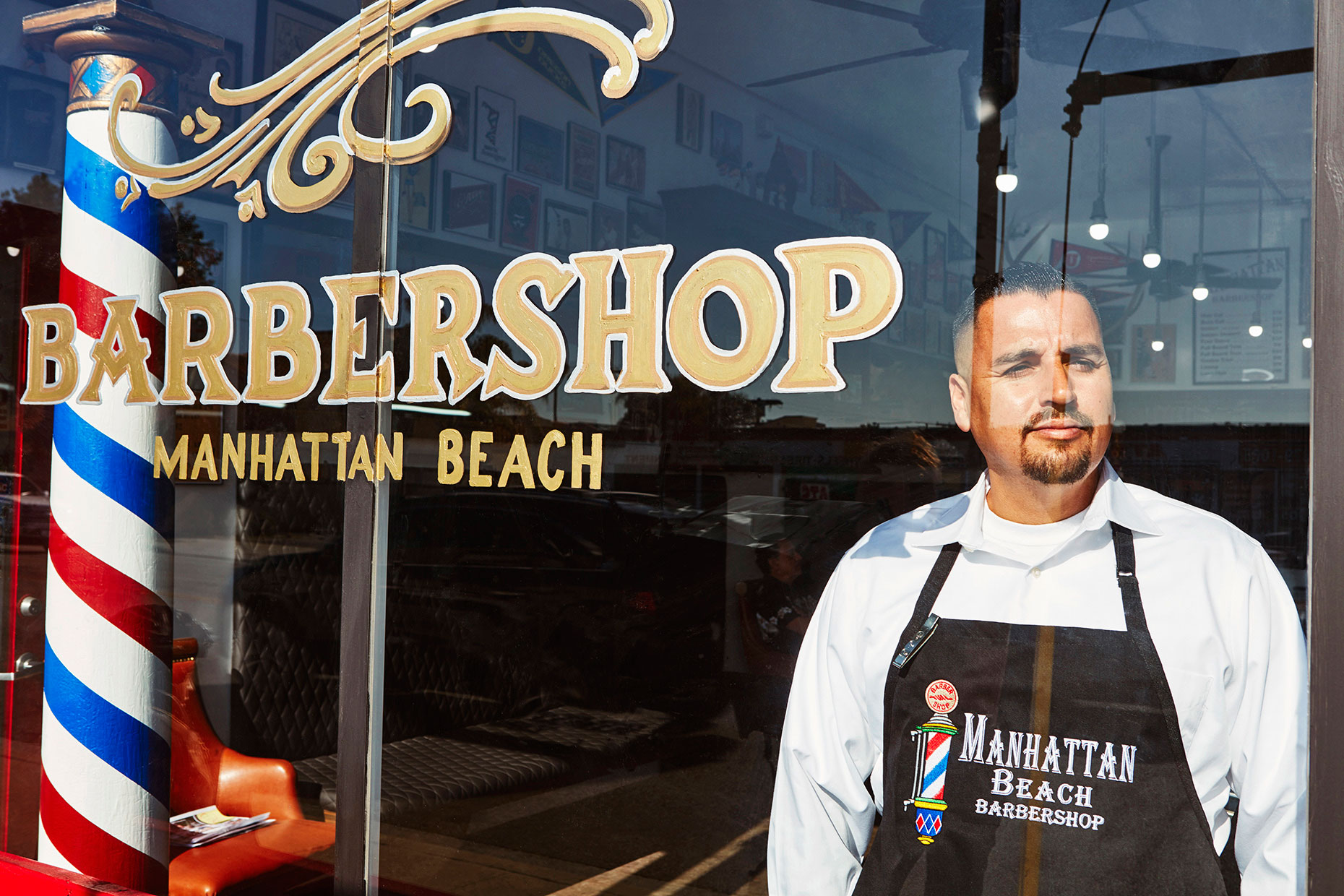 Business owner looking out window of barbershop.