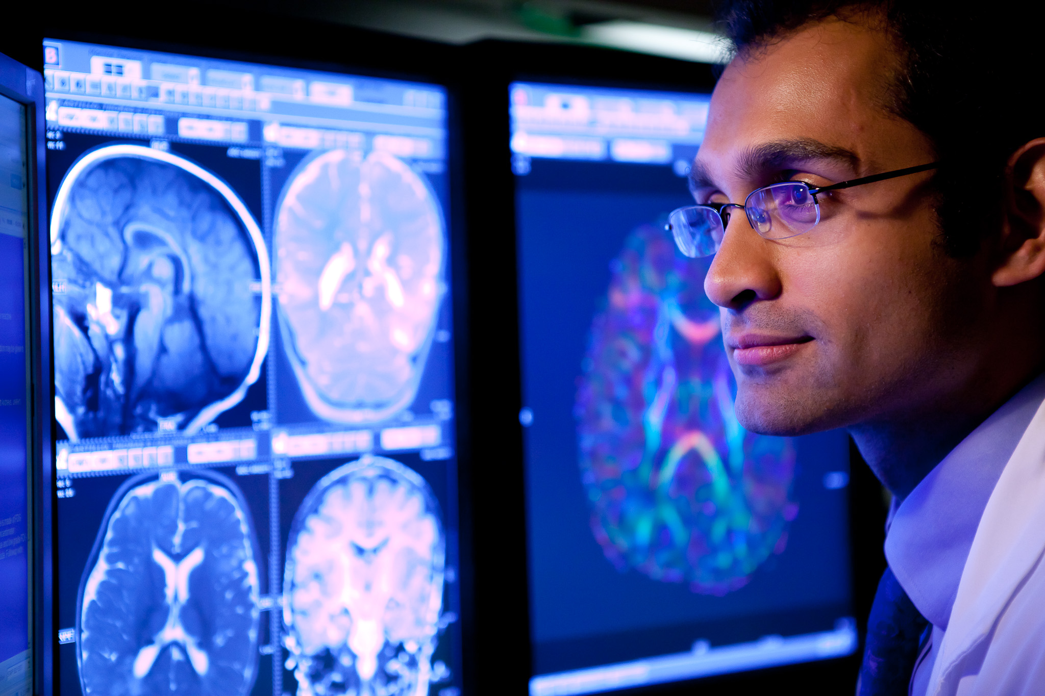 Doctor reviewing C.T. scans on monitor in hospital.