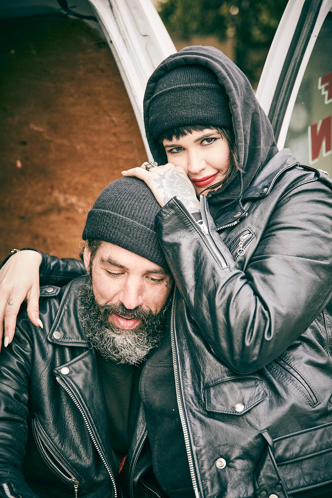 A couple wearing leather biker gear and smiling 