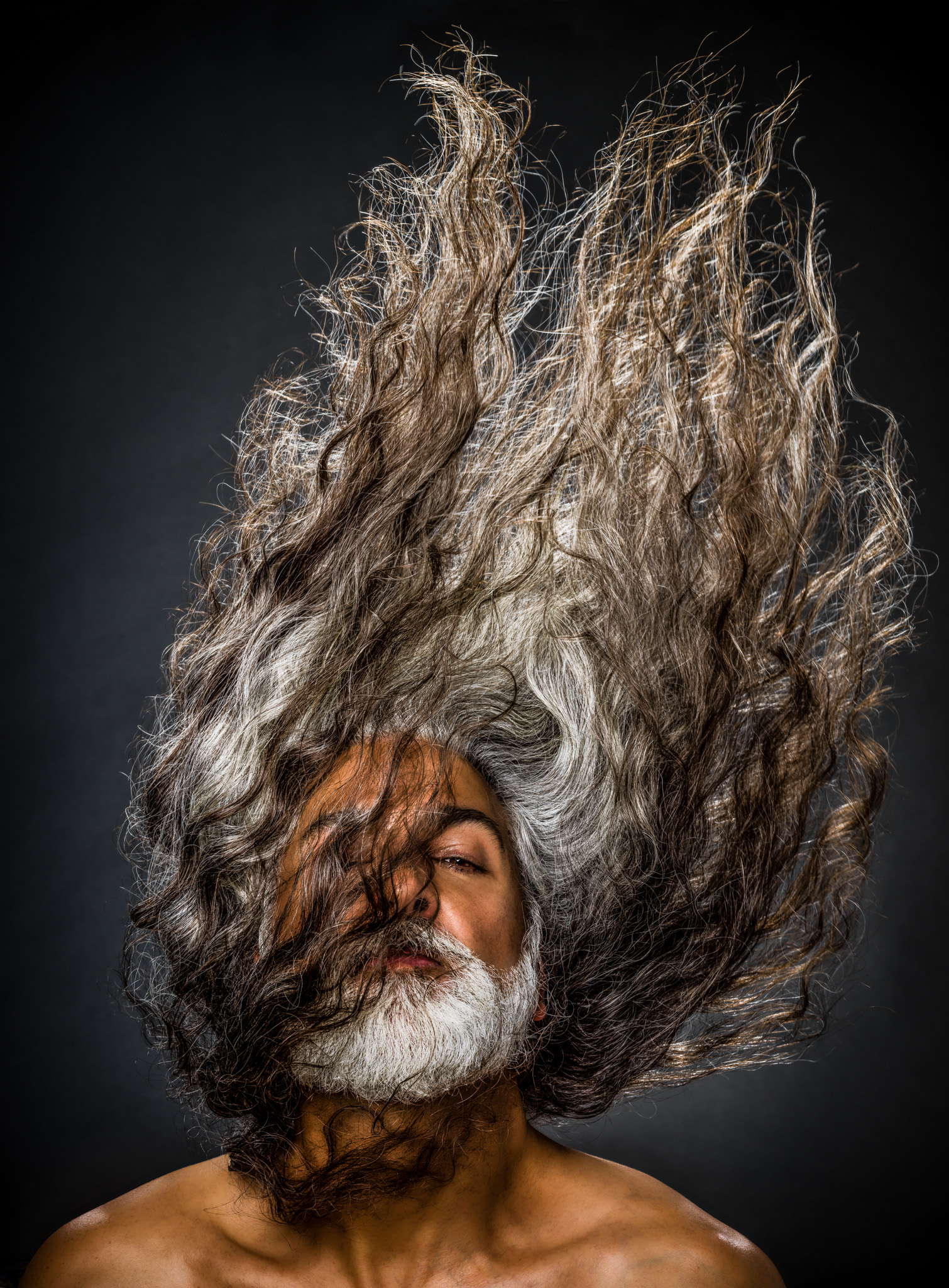 Portrait of a man with very long hair flipping it into the air up over his head. © 2017 Dana Hursey Photography