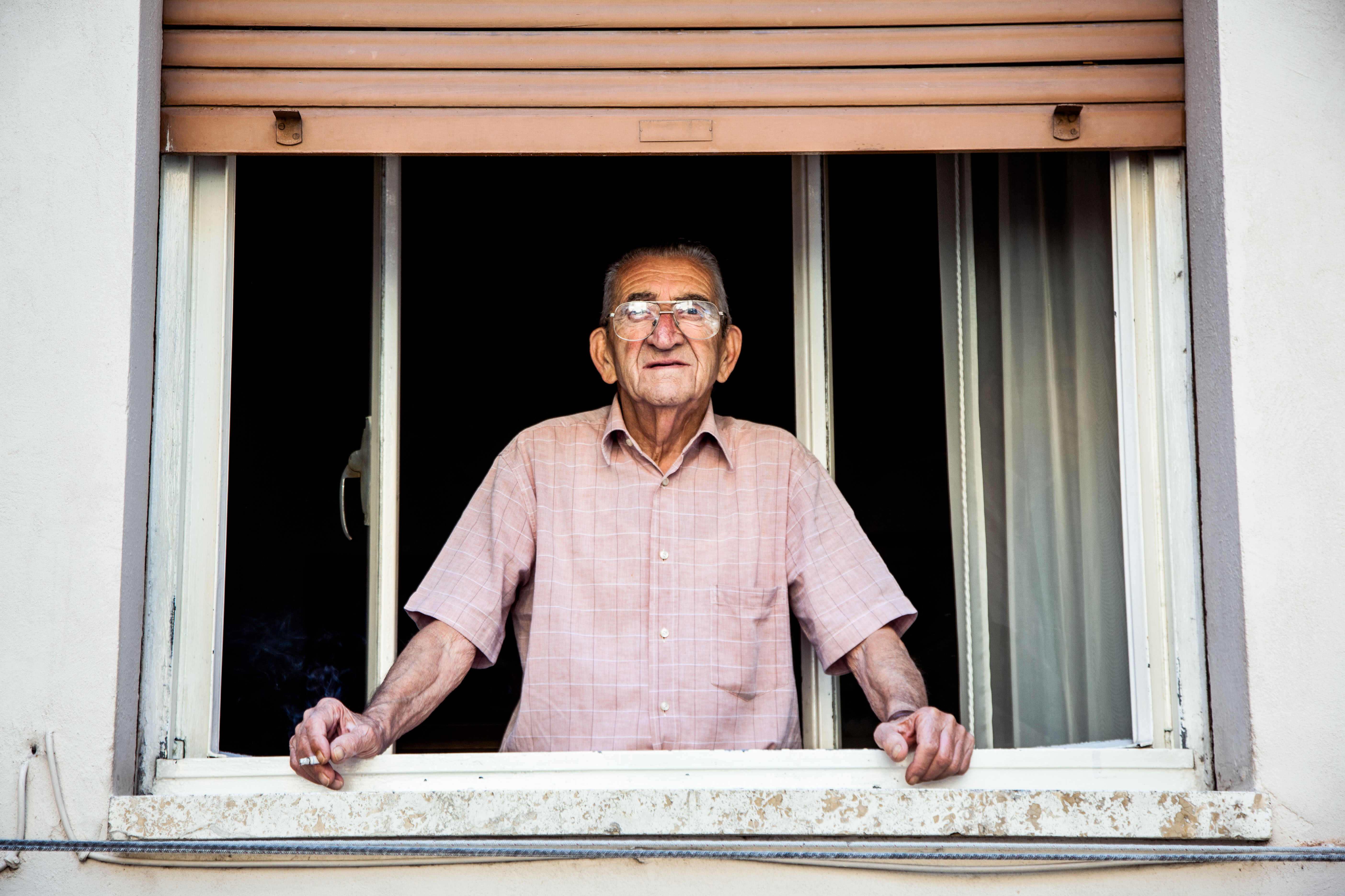 Senior Man Smoking in Window