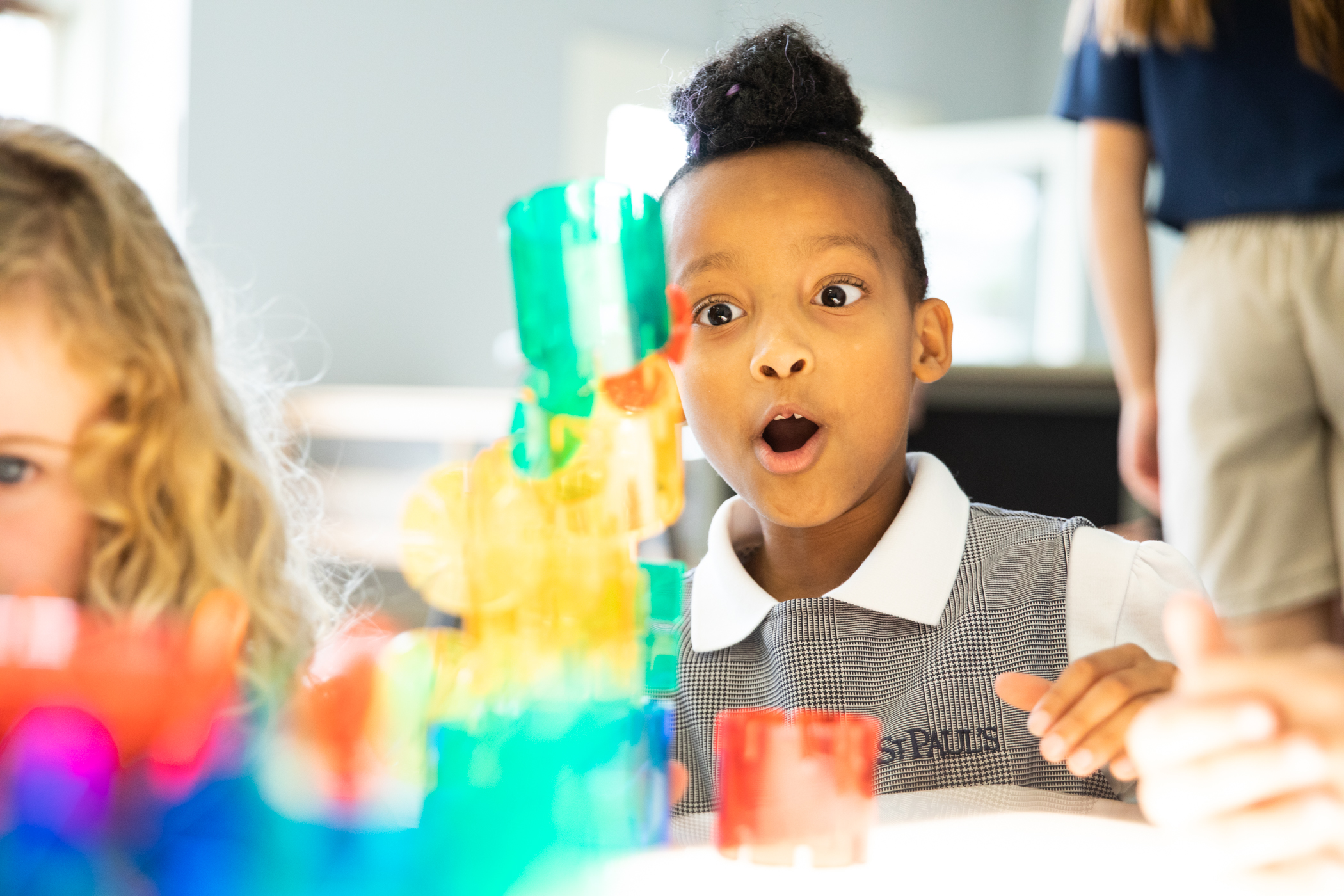 Tween using colorful blocks in classroom.