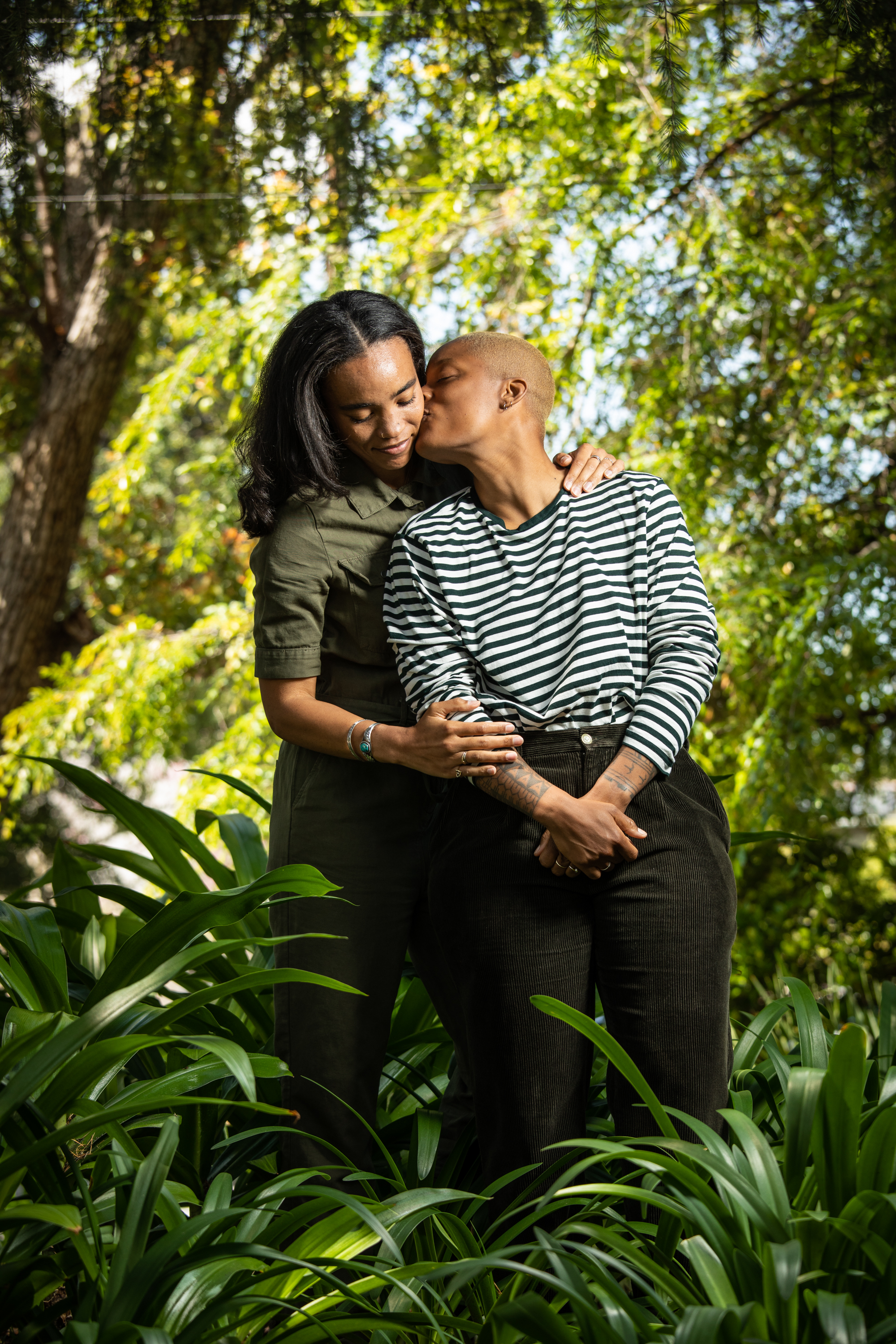 Environmental portrait of an African American same sex couple kissing.