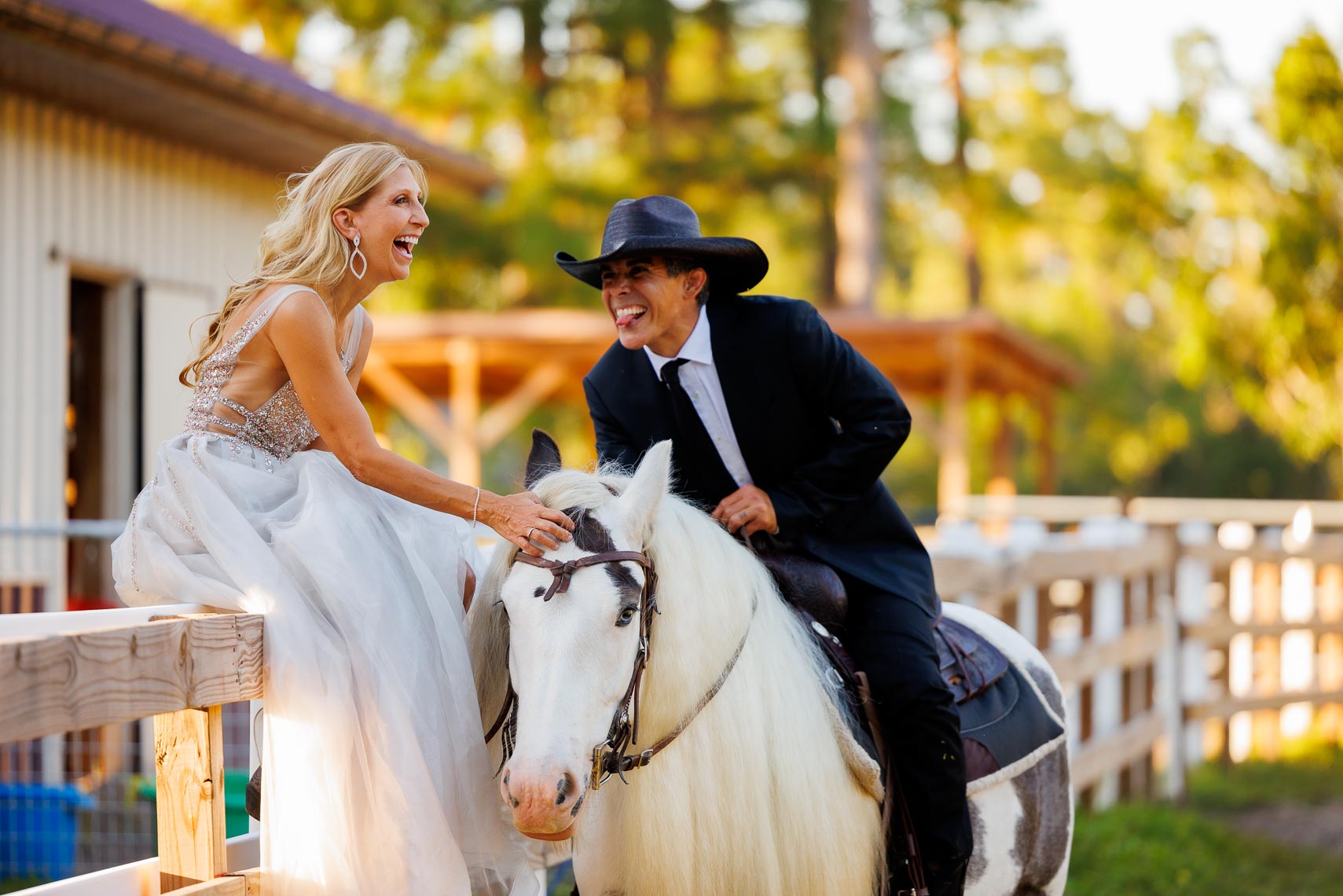 A couple laughs together enjoying their ranch and horses.