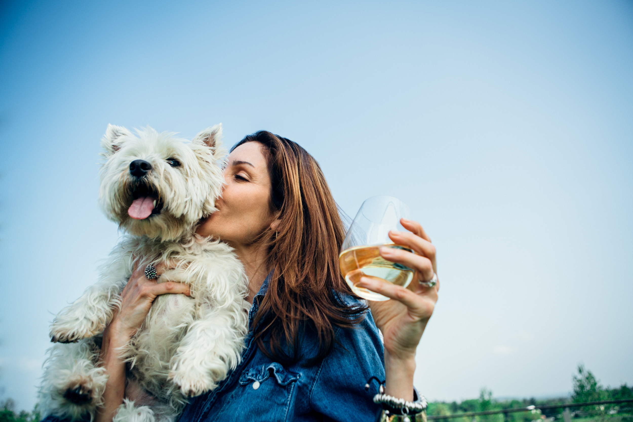 Woman holding a dog and drinking wine at Big Cork Vineyards in Maryland.