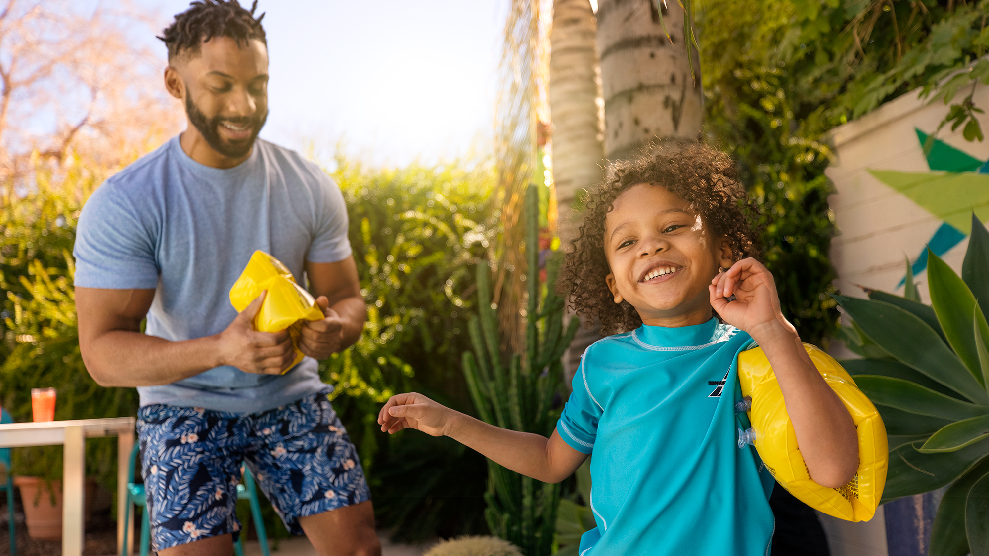 African American father and son, enjoying summer, in a happy moment, by the swimming pool. 
