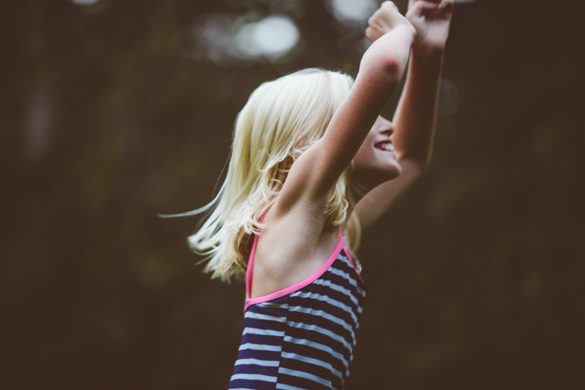Girl dancing by swimming pool