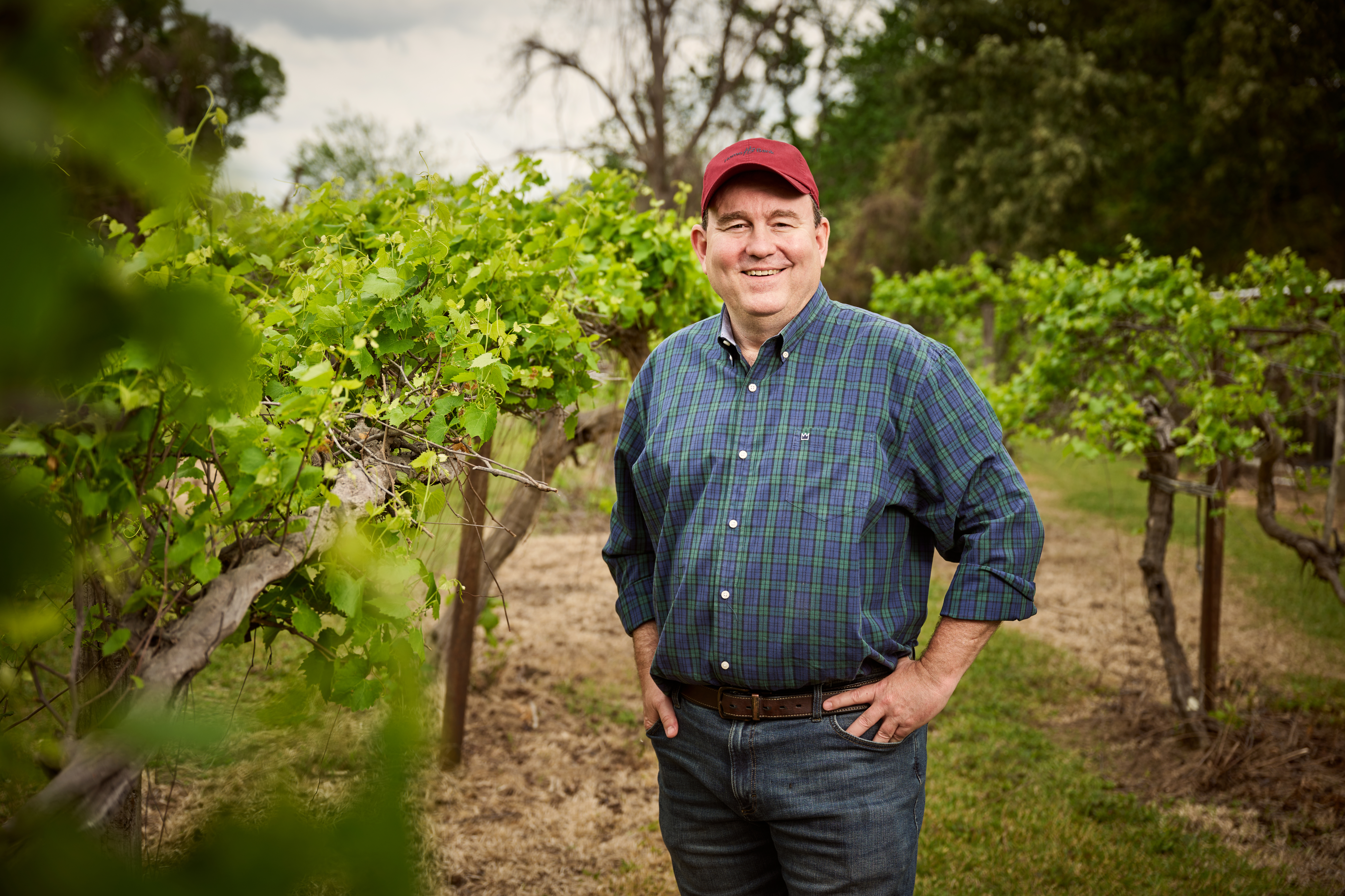 In the heart of the vineyard, every row tells a story of dedication and passion. With a smile of pride and the lush vines surrounding him, this is where hard work meets the beauty of nature.