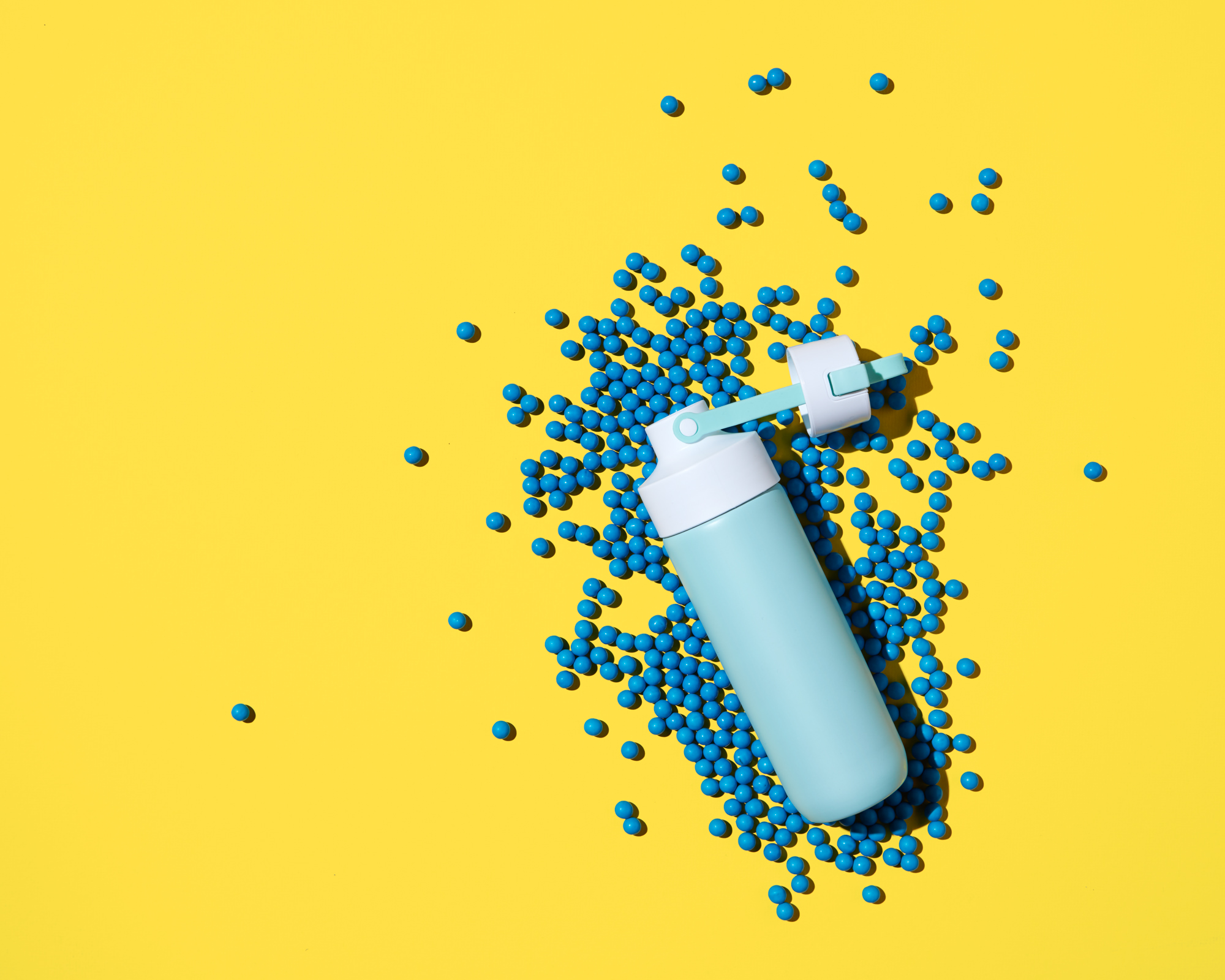 Product photography of abstract top down waterbottle composition in hard light.