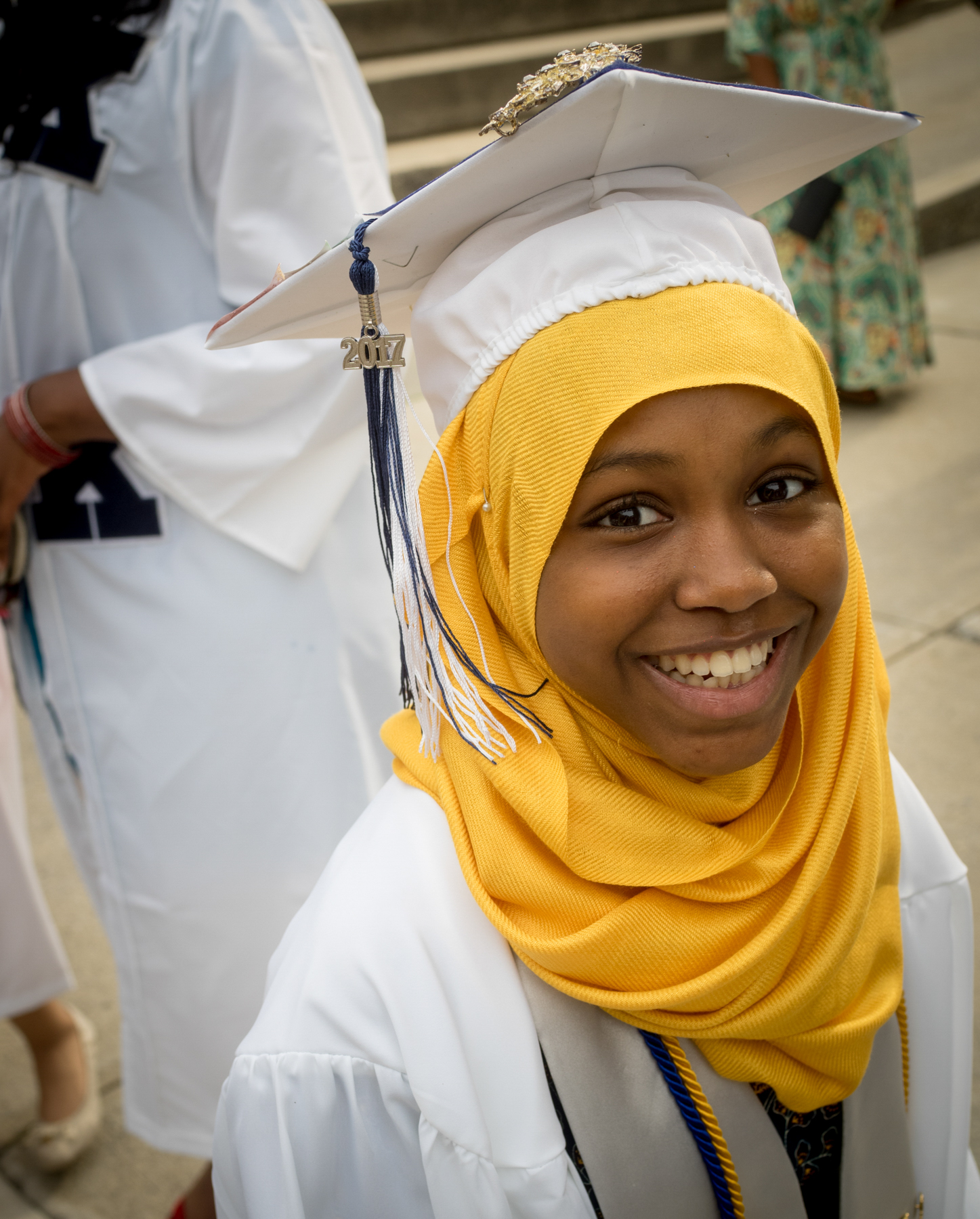 Portrait photograph of young elementary school aged girl in graduation cap and gown.